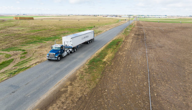 Aerial of JDH truck driving on a paved road